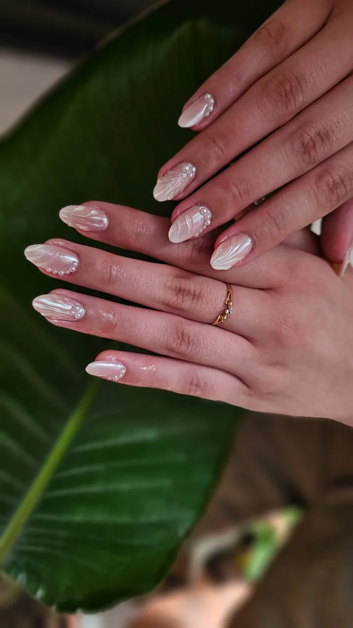 Uñas blancas perladas con detalles en relieve del estudio Burbujas Nails